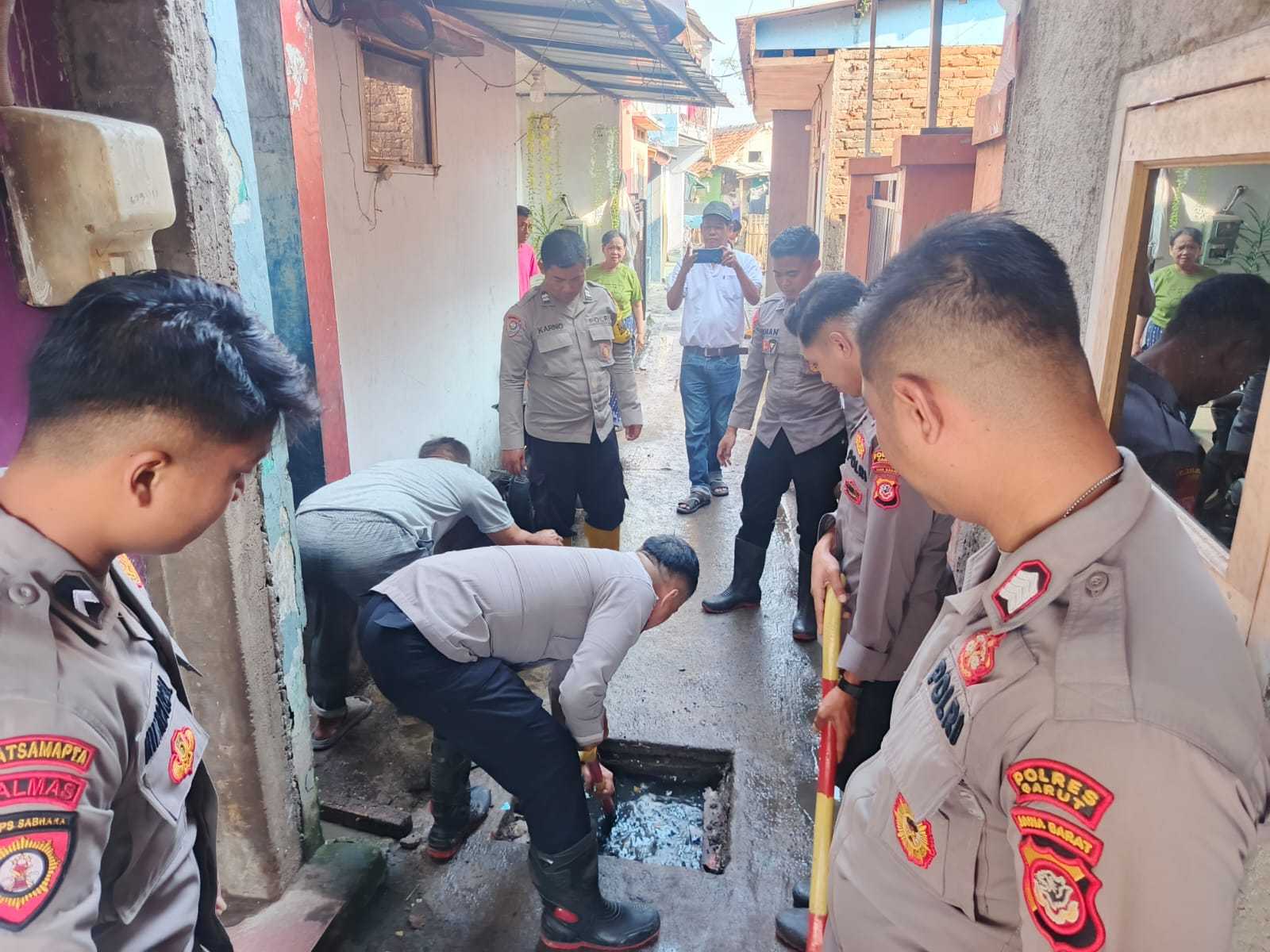 Polres Garut Bantu Warga Bersihkan Sisa Material Banjir di Wanaraja